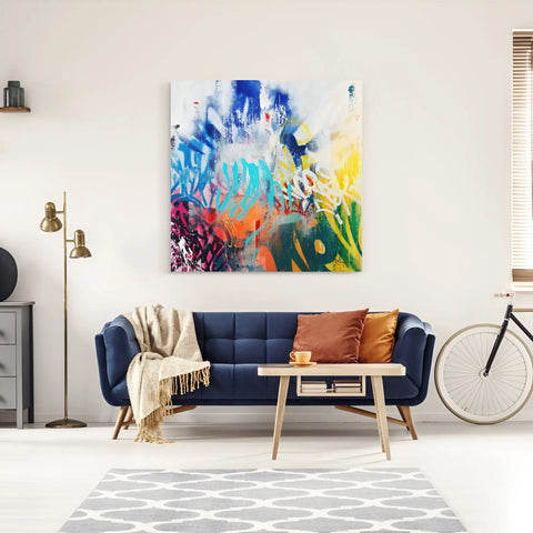 A living room with a blue couch and a large painting on the wall