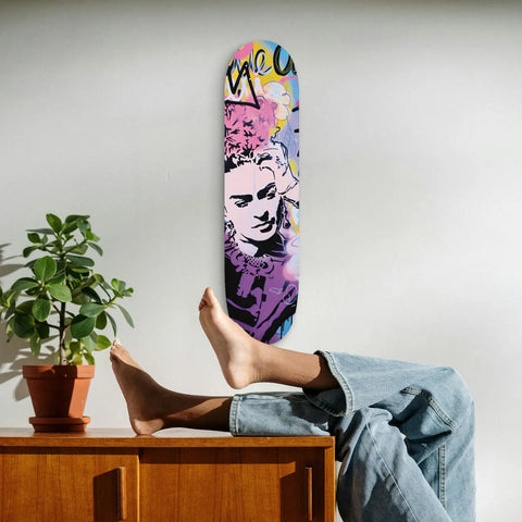 Colorful skateboard deck featuring artistic portrait design in pink and purple tones.