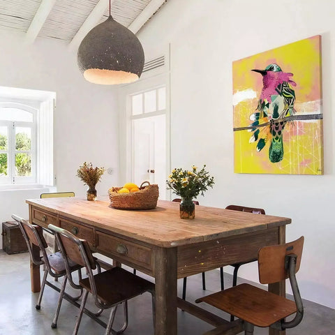 A dining table with chairs and a painting on the wall