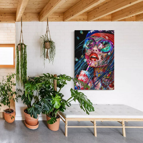 A painting of a woman with long hair and a pink dress is hanging on the wall in a room with plants