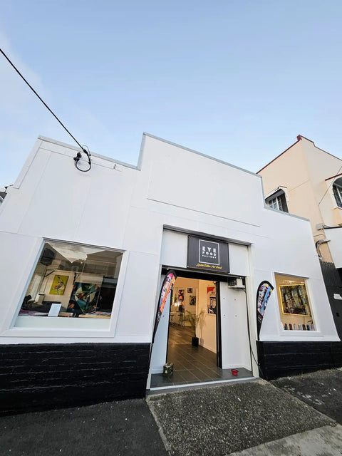 White-painted storefront with a black base and large display windows.